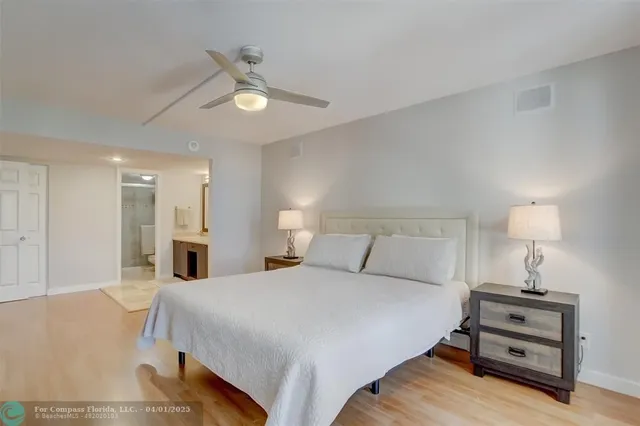 a spacious bedroom with a bed and a lamp