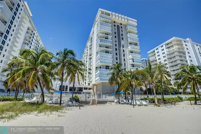 front view of a tall building next to a yard