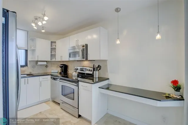 a kitchen that has a lot of cabinets and appliances in it