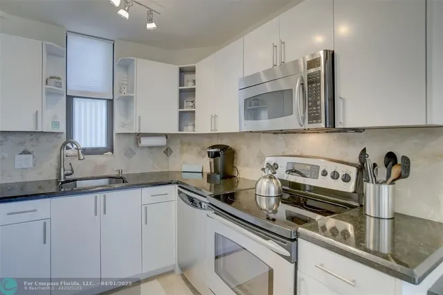 a kitchen with stainless steel appliances granite countertop a sink stove and cabinets