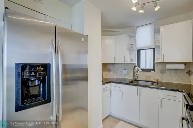 a kitchen with a refrigerator and a sink