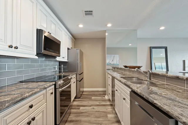 a kitchen with stainless steel appliances granite countertop a stove and a sink