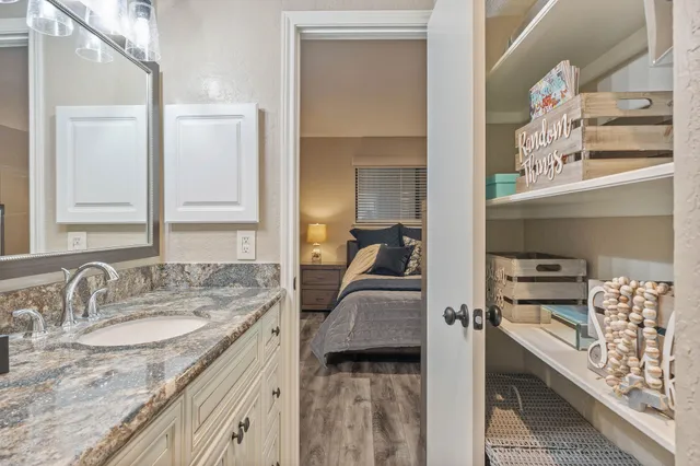 a en suite bathroom with a granite countertop sink and a mirror