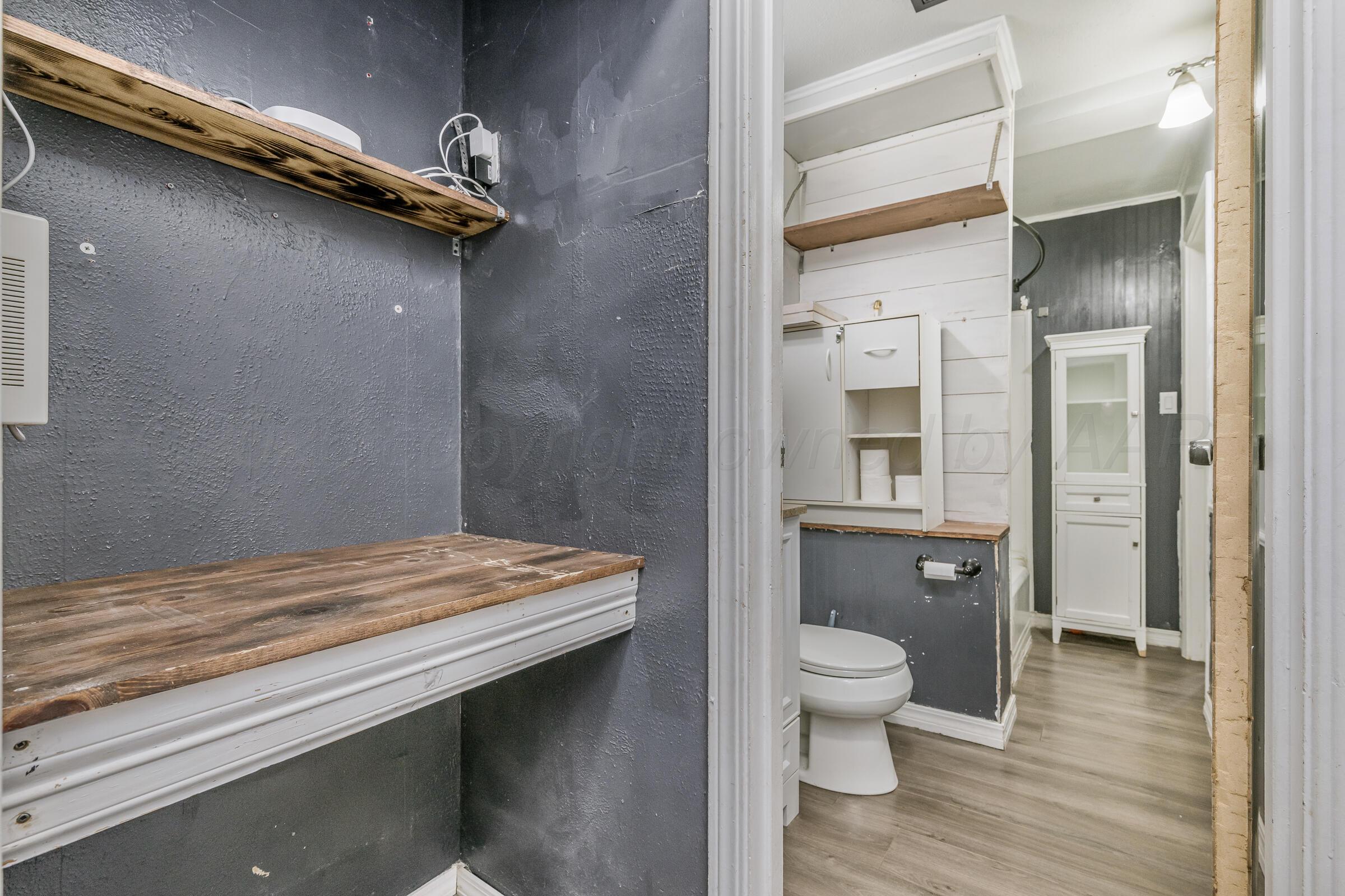 4429 Bowie Street Amarillo, TX 79110 - Photo 14 of 20 a bathroom with a granite countertop sink a toilet and shower