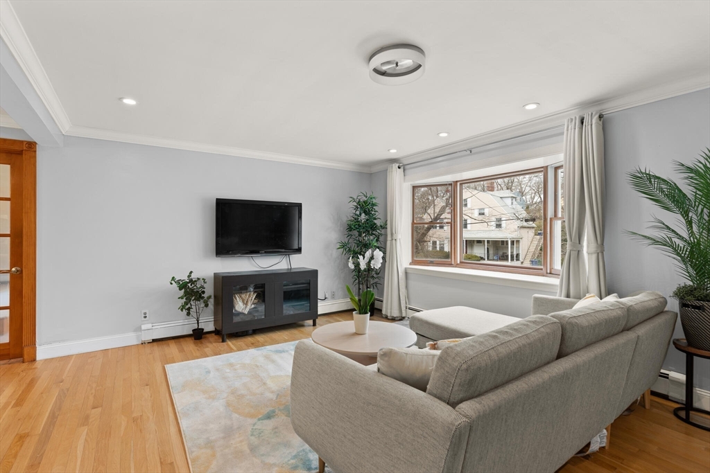 50 Thurston Road, Unit 50 Newton, MA 02464 - Photo 7 of 26 a living room with furniture a flat screen tv and a fireplace