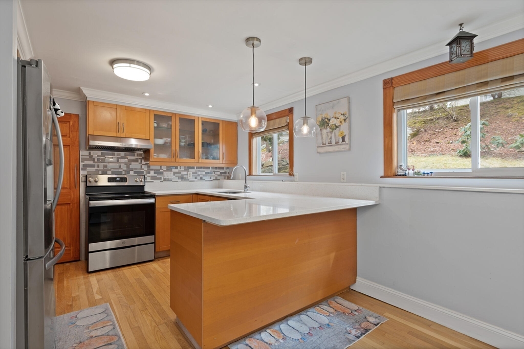 50 Thurston Road, Unit 50 Newton, MA 02464 - Photo 9 of 26 a kitchen with stainless steel appliances granite countertop a stove a sink and a refrigerator with wooden floor