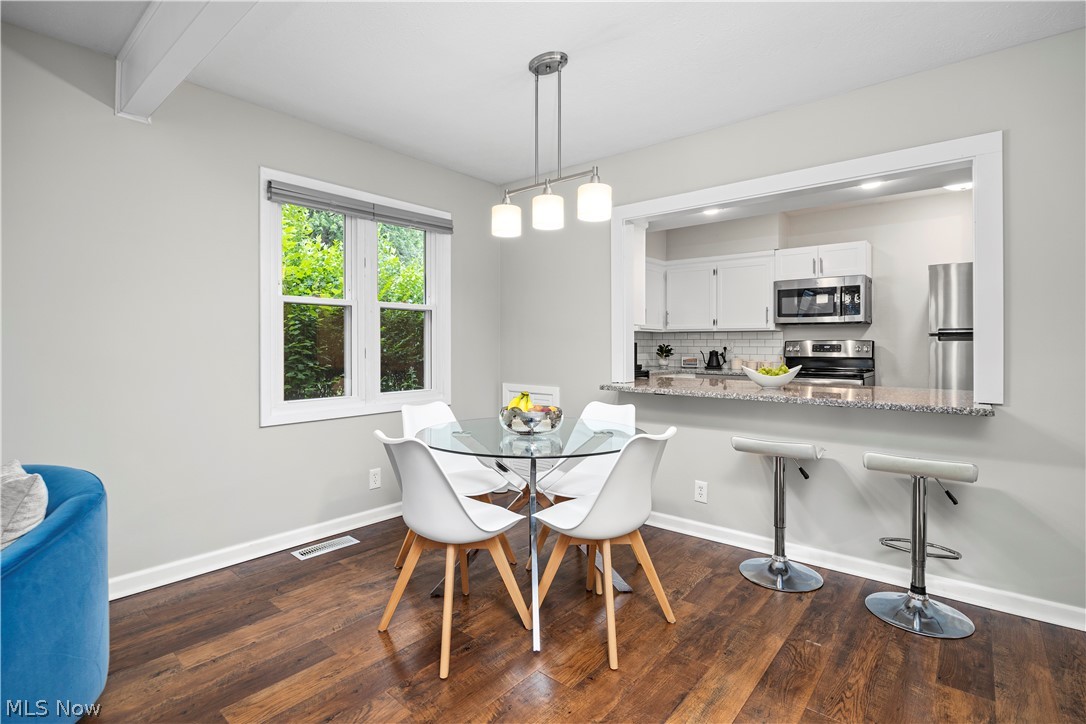 184 Sunset Road Avon Lake, OH 44012 - Photo 10 of 35 Dining area featuring dark wood-type flooring and beamed ceiling