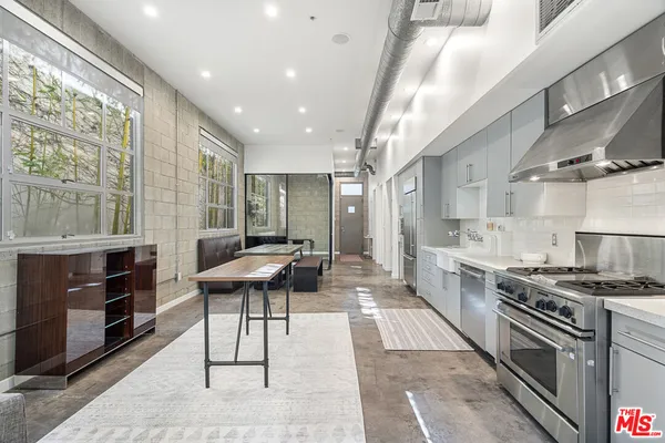 a kitchen with stainless steel appliances kitchen island granite countertop a stove a sink and a refrigerator