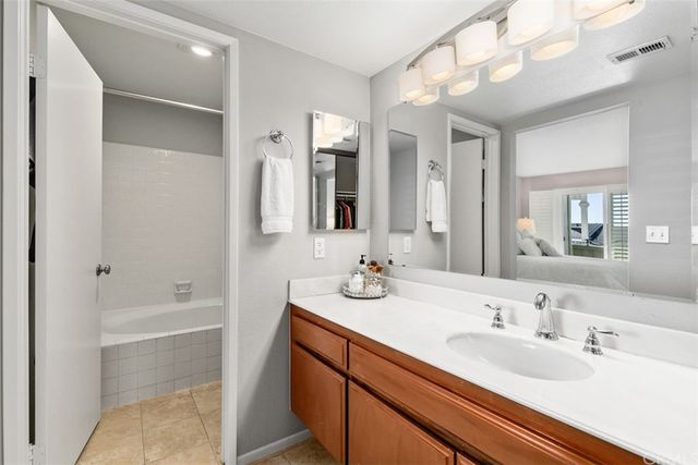 a bathroom with a tub sink and mirror