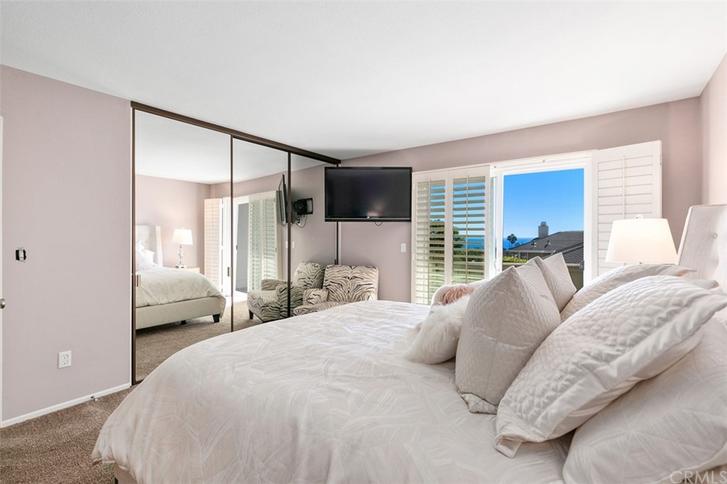 24746 Evening Star Drive, Unit 18 Dana Point, CA 92629 - Photo 31 of 42 a bedroom with a large bed and a large window
