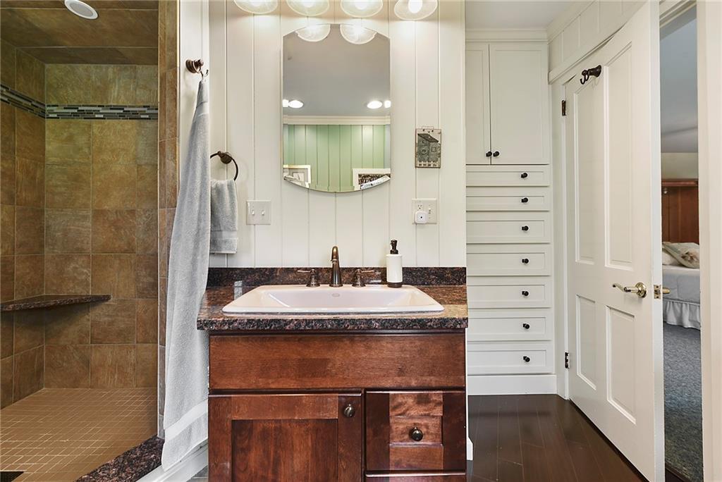 637 East McMurray Road Canonsburg, PA 15317 - Photo 26 of 50 Updated full bath featuring a tiled walk-in shower, granite vanity, and charming built-in wall drawers—offering both style and smart, functional storage.