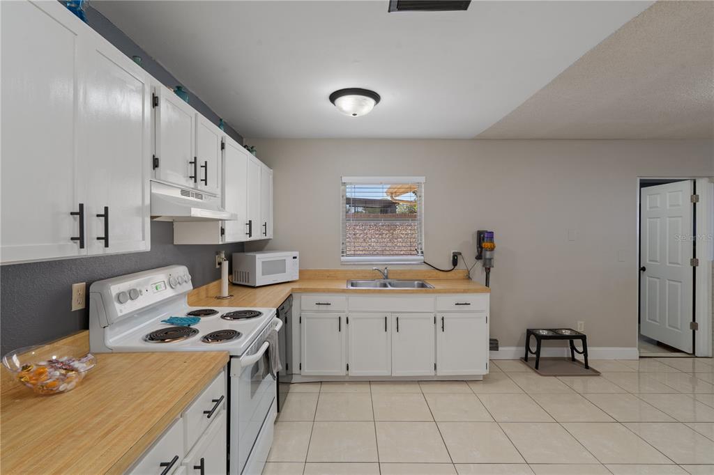 5025 Bromley Avenue Spring Hill, FL 34609 - Photo 13 of 41 a kitchen with cabinets a sink and white appliances