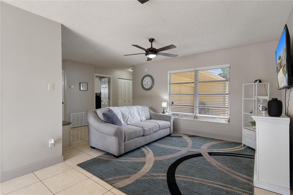 5025 Bromley Avenue Spring Hill, FL 34609 - Photo 9 of 41 a living room with furniture a fireplace and a flat screen tv