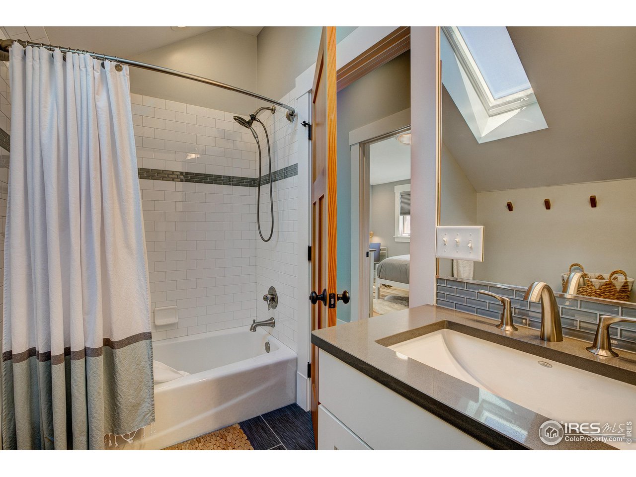 406 North Whitcomb Street Fort Collins, CO 80521 - Photo 16 of 33 a bathroom with a granite countertop sink a mirror and a bathtub
