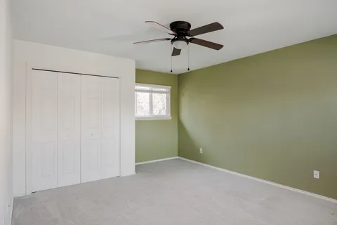 an empty room with a window and a fan