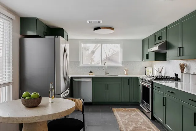a kitchen with stainless steel appliances a sink a stove and a refrigerator