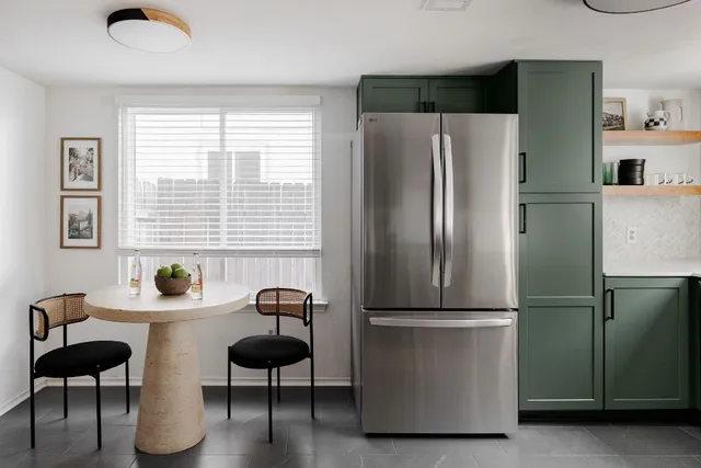 a kitchen with stainless steel appliances a refrigerator and a chair