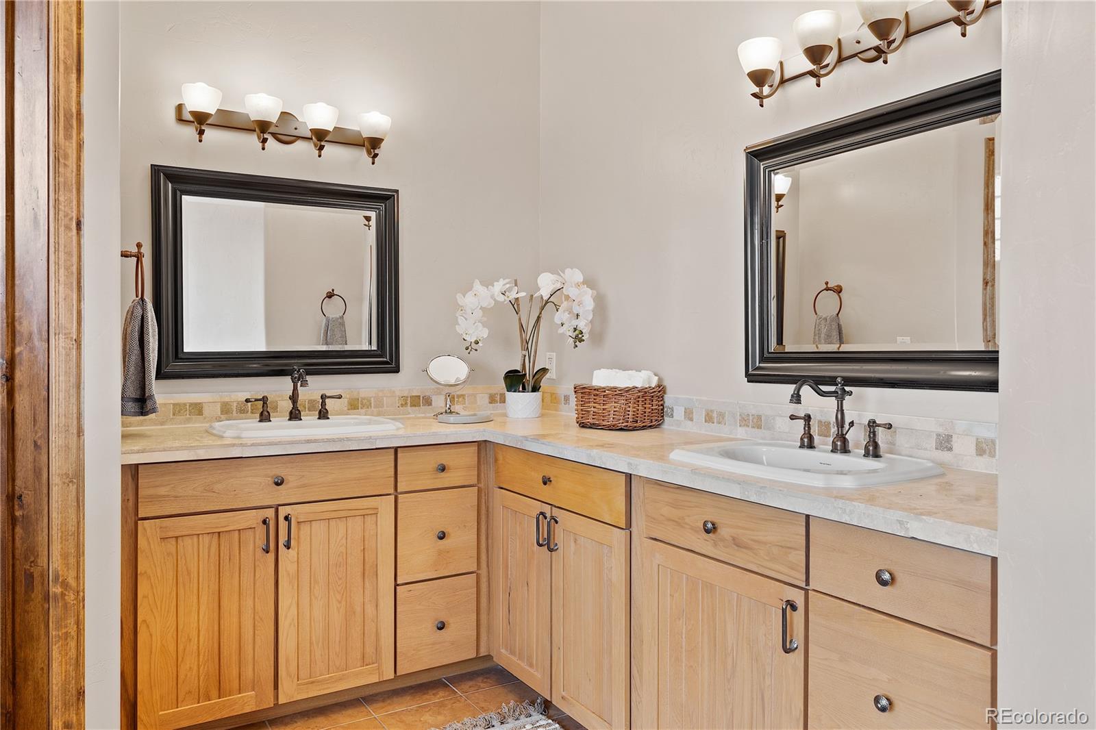 2505 Big Bear Circle Sedalia, CO 80135 - Photo 19 of 49 a bathroom with a double vanity sink and a mirror