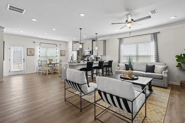 a dining room with wooden floor a glass table and chairs