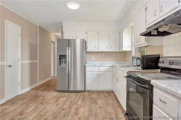 a kitchen with a refrigerator sink and cabinets