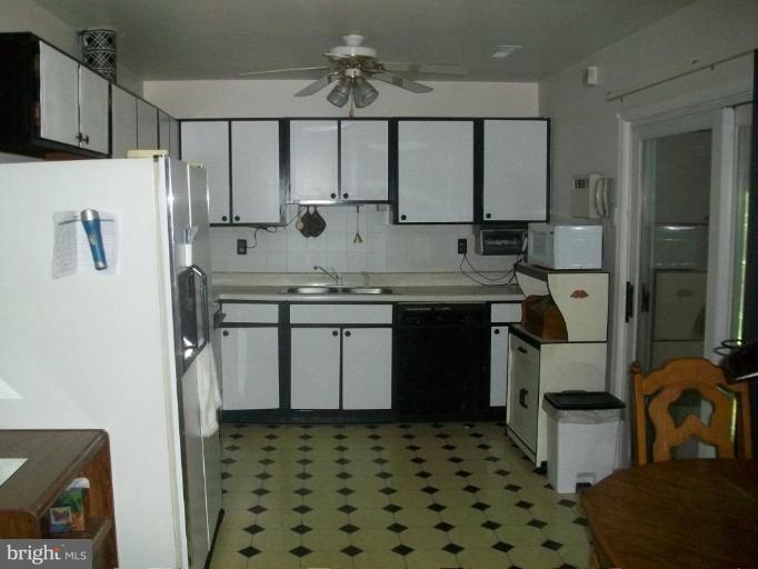 48420 Mattapany Road Lexington Park, MD 20653 - Photo 4 of 7 a kitchen with stainless steel appliances a sink a stove a refrigerator and cabinets