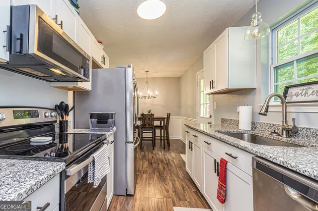 a kitchen with stainless steel appliances granite countertop a refrigerator and a sink