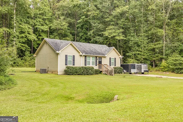 a view of a house with a yard and sitting area