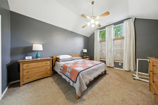 a spacious bedroom with a bed and a chandelier