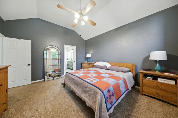a bedroom with a large bed and a chandelier