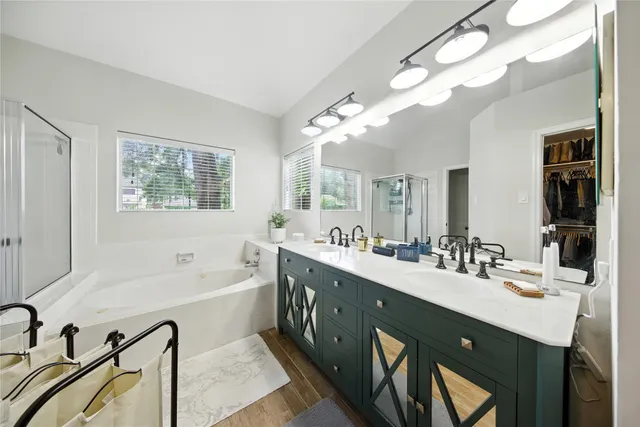 a spacious bathroom with a double vanity sink a mirror and a bathtub
