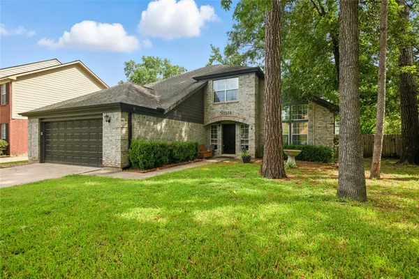 a view of a house with backyard and a tree