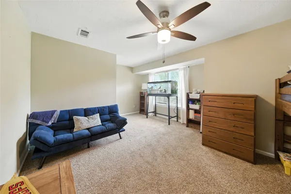 a living room with furniture and a ceiling fan