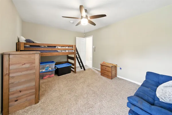 a bedroom with furniture and a ceiling fan