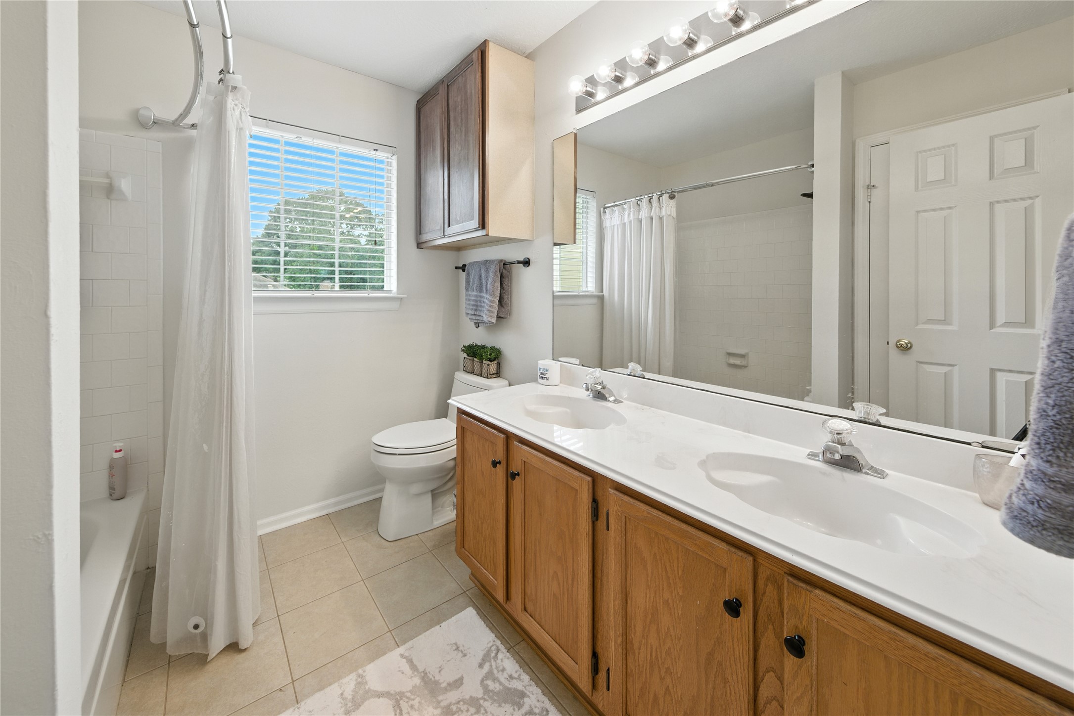 115 Regency Way Conroe, TX 77304 - Photo 26 of 32 a spacious bathroom with a double vanity sink toilet and a mirror