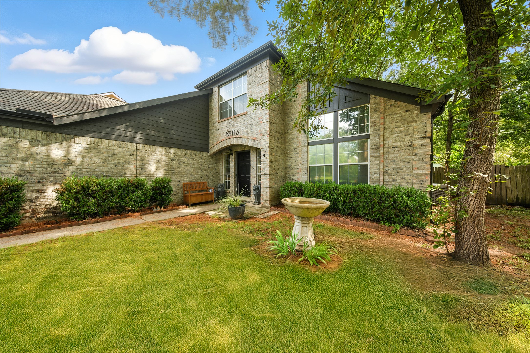 115 Regency Way Conroe, TX 77304 - Photo 3 of 32 a front view of a house with a yard table and chairs