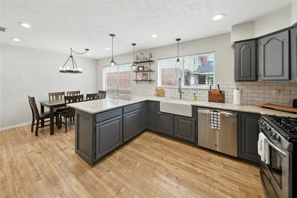 a kitchen with a sink a counter top space stainless steel appliances and cabinets