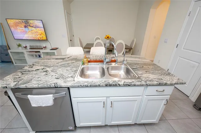 a kitchen with stainless steel appliances granite countertop a sink a stove a microwave a refrigerator and cabinets