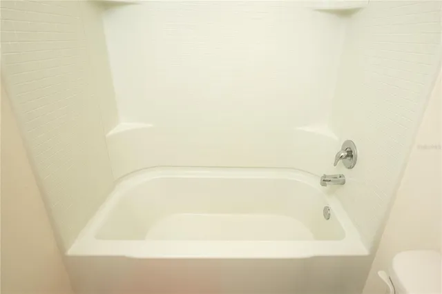 a bedroom with a bed and dresser with mirror