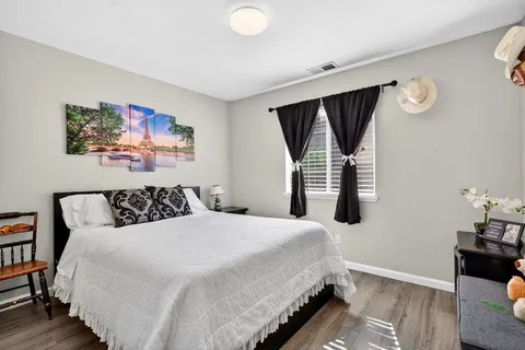 a bedroom with a bed and painting on the wall