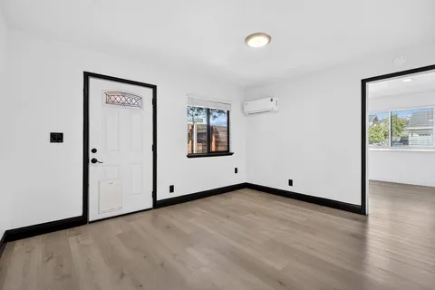 a view of empty room with wooden floor