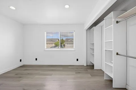 a view of empty room with wooden floor and cabinet