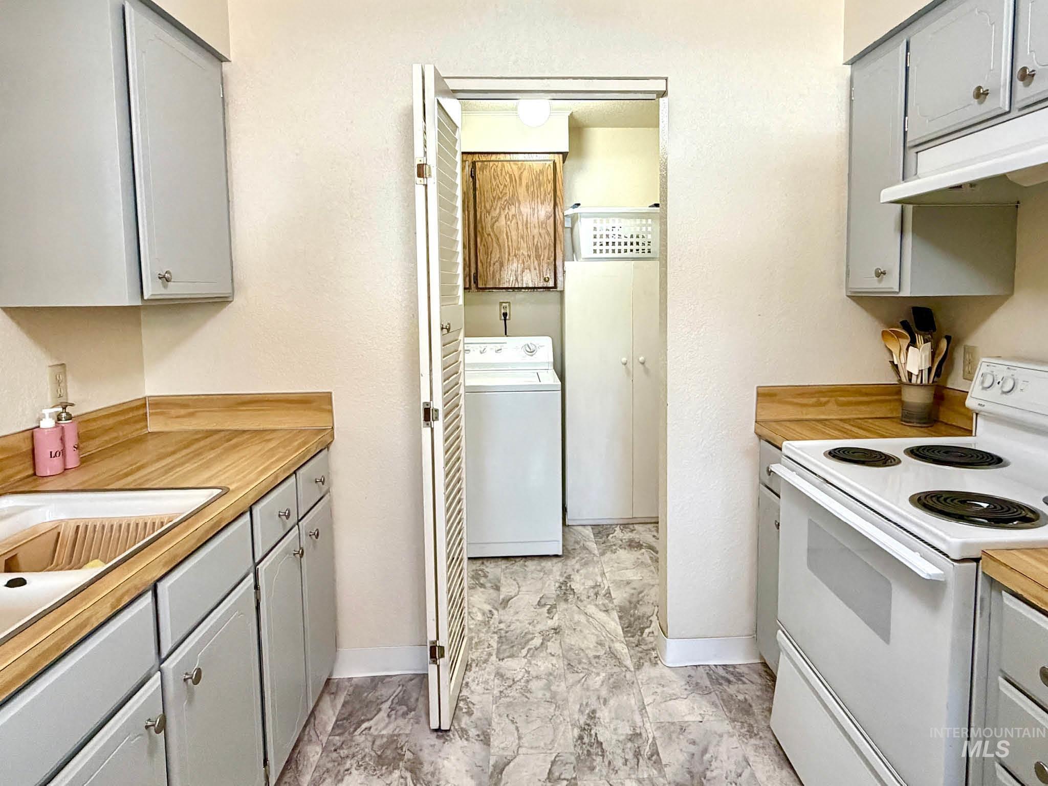 3920 North Maple Grove Road Boise, ID 83704 - Photo 23 of 29 Kitchen featuring light gray cabinetry, wood-finish countertops, and a white electric range