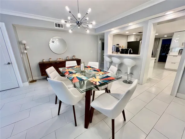 a view of a dining room and a kitchen with furniture and mirror