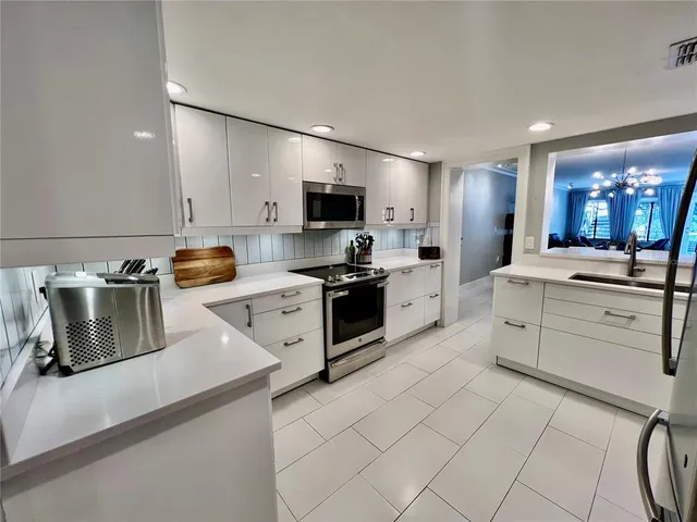 a kitchen with white cabinets and appliances
