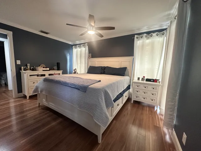 a bedroom with a bed and wooden floor