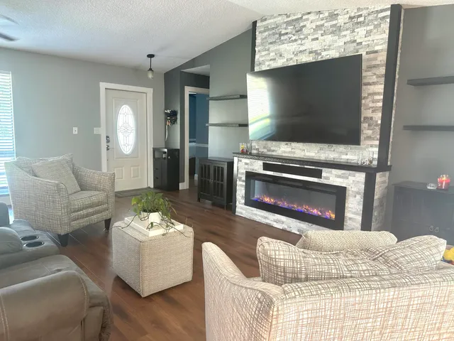 a very nice looking room with wooden floor and furniture