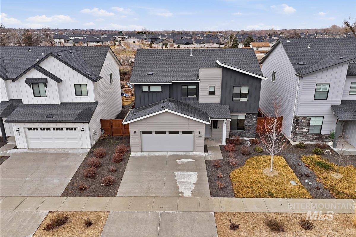 6937 South Sunfish Way Boise, ID 83709 - Photo 1 of 1 Modern farmhouse style home with board and batten siding, roof with shingles, driveway, and a residential view