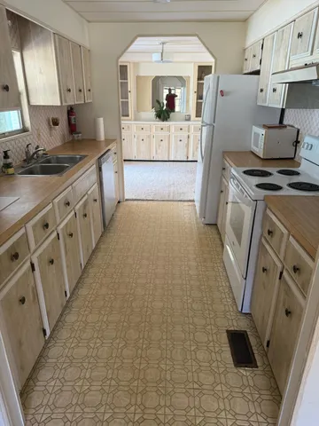 a kitchen with stainless steel appliances a stove a sink and a refrigerator