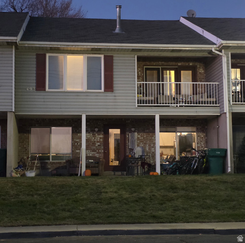 493 East 2000 S Street Orem, UT 84058 - Photo 1 of 1 Rear view of house featuring a yard, a balcony, and brick siding