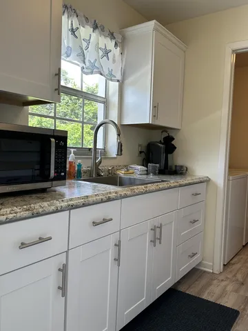 a kitchen with granite countertop a sink a stove and cabinets